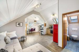 a living room with a white couch and a kitchen at Haus am Bach in Benediktbeuern