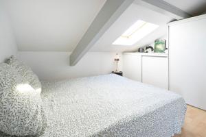 a white bedroom with a bed and a window at Charmant T2 centre Capbreton in Capbreton