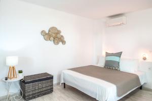 a white bedroom with a bed and a lamp at Luna Rossa Milos - Lavender in Provatas +21 photos