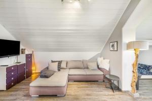 a living room with a couch and a tv at Haus am Bach in Benediktbeuern