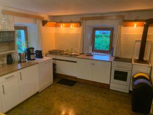a kitchen with white cabinets and a sink and a stove at Ferienwohnung Durst 2 in Mayrhofen