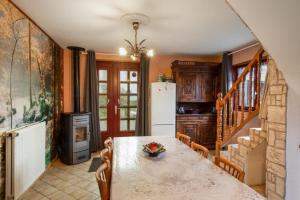 a kitchen with a table and a refrigerator at Location Vacances Des 4 Vents in Girmont-Val-dʼAjol