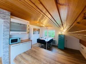 a kitchen with a wooden ceiling and a table at Friedrichshafen im Grünen genießen in Friedrichshafen
