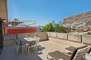 a patio with a table and chairs on a balcony at Ca Luis in Mogán