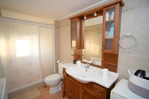 a bathroom with a sink and a toilet and a mirror at A View From The Attic Window in Kyparissia +18 photos