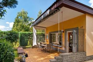 a house with a patio with a table and chairs at Ferienhaus am Rande der Lewitz in Garwitz