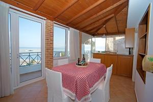a dining room with a table and views of the ocean at A View From The Attic Window in Kyparissia
