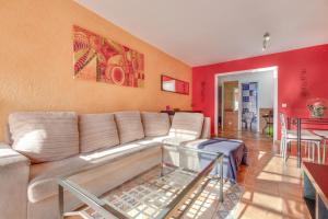 a living room with a white couch and red walls at La Casa De Enzo in Playa de las Americas