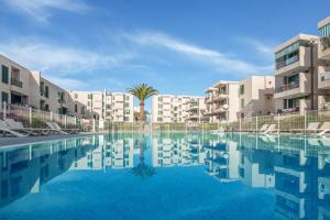 a swimming pool in front of some apartment buildings at La Casa De Enzo in Playa de las Americas