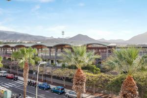 a group of palm trees in front of a building at La Casa De Enzo in Playa de las Americas