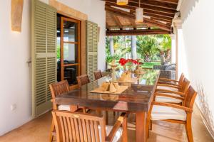 a dining room with a wooden table and chairs at Can Xisco in Artá