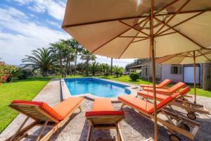 a group of chairs and an umbrella next to a pool at Can Xisco in Artá