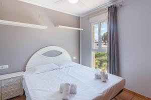 a bedroom with a white bed and a window at Par3 in Oliva