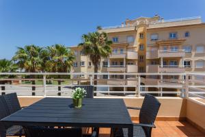 a black table and chairs on a balcony with a building at Par3 in Oliva