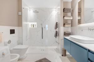 a white bathroom with a toilet and a sink at Casa Zar Ferienwohnung in Verano +31 photos