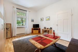 a living room with a table and a tv at Ferienhaus Feldblick in Karwitz
