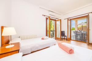 a bedroom with two beds and a balcony at Tomymar in Cala Ratjada +30 photos