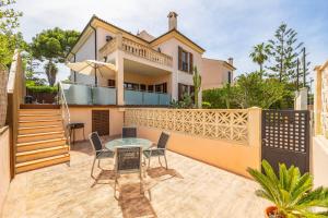 a patio with a table and chairs in front of a house at Tomymar in Cala Ratjada