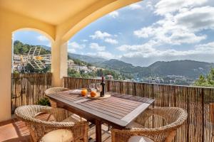 a table with a bottle of wine and oranges on a balcony at Vistasol Port de Soller in Sóller
