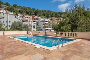 a swimming pool on a patio with buildings in the background at Vistasol Port de Soller in Sóller