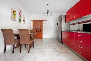 a kitchen with red cabinets and a table with chairs at Casa Auxilia in Araya +16 photos