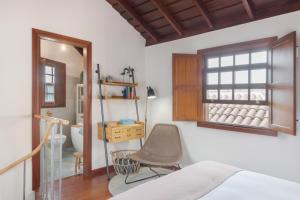 a bedroom with a bed and a chair and a window at El Bebedero de Los Sauces in San Andres y Sauces +28 photos