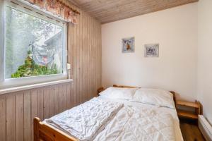 a bedroom with a bed and a window at Bungalow 91 in Zeulenroda