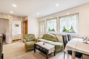 a living room with a couch and chairs and a table at Bungalow 91 in Zeulenroda