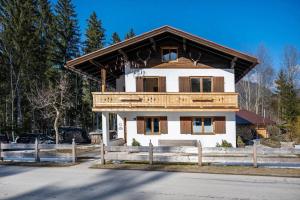 a white house with a wooden roof at Fewo Am Steinbach - Lofer in Reit im Winkl