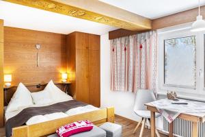 a bedroom with a bed and a desk and a table at Berggold in Nesselwängle