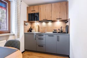 a kitchen with stainless steel appliances and wooden cabinets at Fewo Am Steinbach - Lofer in Reit im Winkl +21 photos