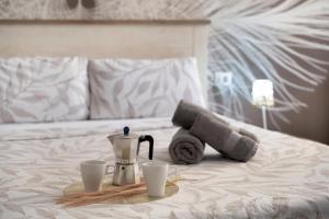 a tray with a coffee maker and two cups on a bed at Beach Holidays in Adeje +18 photos