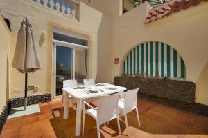 a dining room with a table and chairs and an umbrella at Beach Holidays in Adeje
