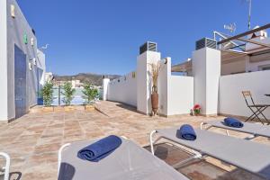 a patio with two beds and a table on a house at Nerja Boutique 202 Deluxe in Nerja