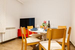a dining room with a table with chairs and a tv at Lemon Tree Apartment in Canet de Mar