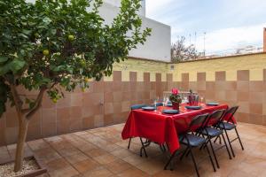 a table with a red table cloth on a patio at Lemon Tree Apartment in Canet de Mar