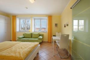 a bedroom with a bed and a couch and a table at Birkethof Studio in Mickhausen