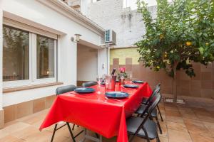 a table with a red table cloth on a patio at Lemon Tree Apartment in Canet de Mar