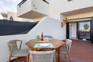 a dining room with a wooden table and chairs at White Studio and Terrace in Albufeira