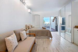 a living room with a couch and a bed and a mirror at White Studio and Terrace in Albufeira