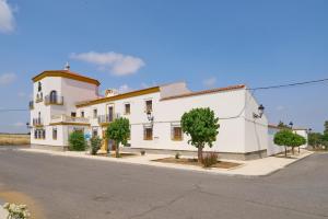 a large white building on the side of a street at Apartamentos Valsequillo Córdoba in Valsequillo
