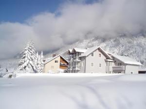 a house in the snow with mountains in the background at Appartment Isabelle Home in Hermagor