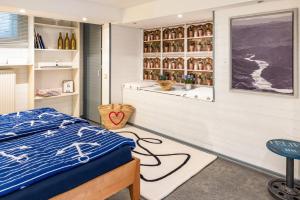a bedroom with a bed and a shelf of bottles at Modernes Landapartment in Seevetal
