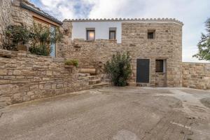 a stone building with a stone wall and a door at Cantó el Sech in Montoliu de Segarra