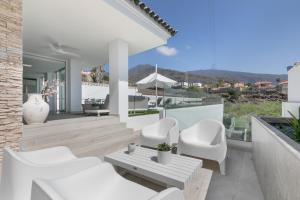 a white patio with white chairs and a table at Private Villa Candelaria in Candelaria