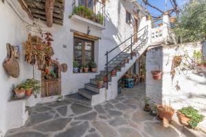 a courtyard with potted plants and stairs in a building at Casa El Portón, Bubión in Bubión