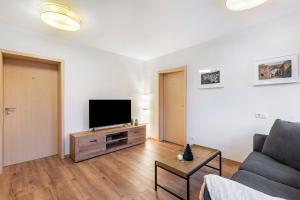 a living room with a couch and a flat screen tv at Ferienwohnung Kraus in Katzenbach