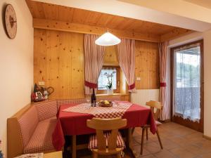 a dining room with a red table and chairs at Ciasa Lino Aloch in Pozza di Fassa