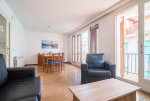 a living room with a couch and chairs and a table at Canet beach 3 in Canet de Mar