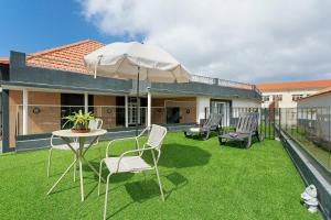 a patio with a table and chairs and an umbrella at Casa Pereira in Ponta do Pargo